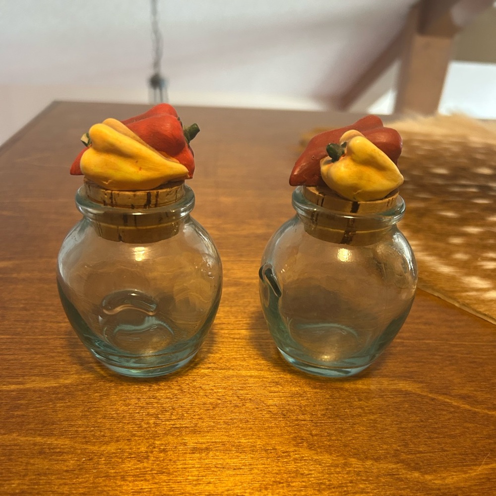 2 Glass spice jars with pepper lids.